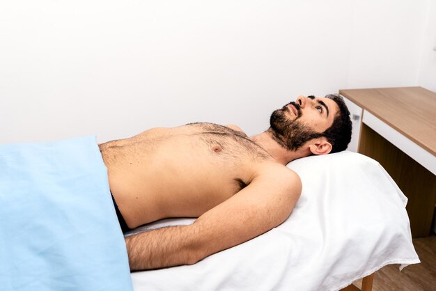 Foto un joven durmiendo en la cama.