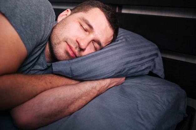 Foto joven durmiendo en la cama