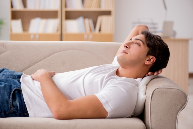 Joven durmiendo en el sofá cama