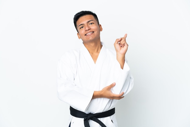 Joven ecuatoriano haciendo karate aislado en la pared blanca mostrando y levantando un dedo en señal de lo mejor