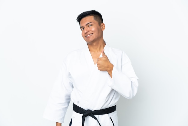 Joven ecuatoriano haciendo karate aislado sobre fondo blanco dando un pulgar hacia arriba gesto