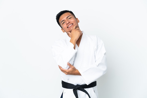 Joven ecuatoriano haciendo karate aislado sobre fondo blanco feliz y sonriente