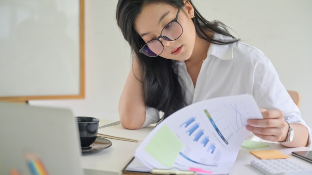 Joven ejecutiva está revisando el desempeño de la compañía.