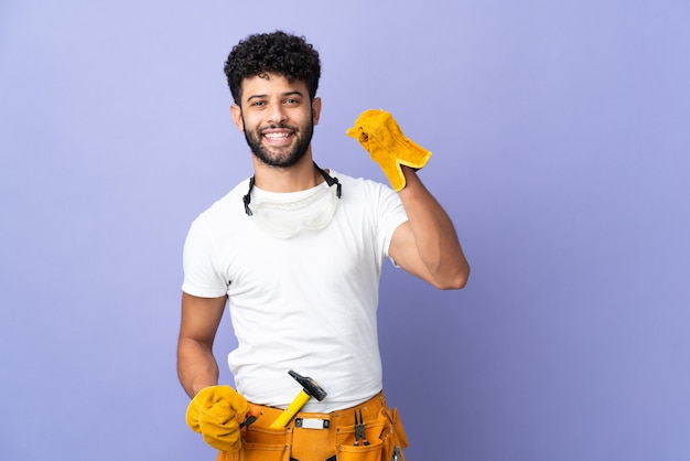 Joven electricista marroquí aislado en la pared púrpura celebrando una victoria