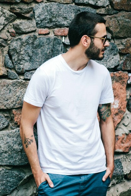 Foto un joven elegante con barba en una camiseta blanca y gafas