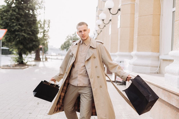 Un joven elegante con bolsas después de una exitosa compra en el Black Friday