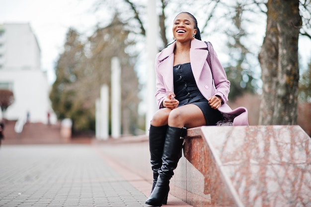 Joven elegante hermosa mujer afroamericana en la calle con abrigo de moda