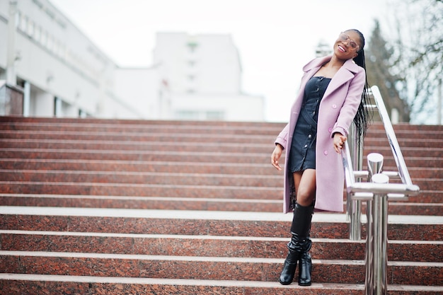 Joven y elegante mujer afroamericana en la calle contra las escaleras con gafas de moda