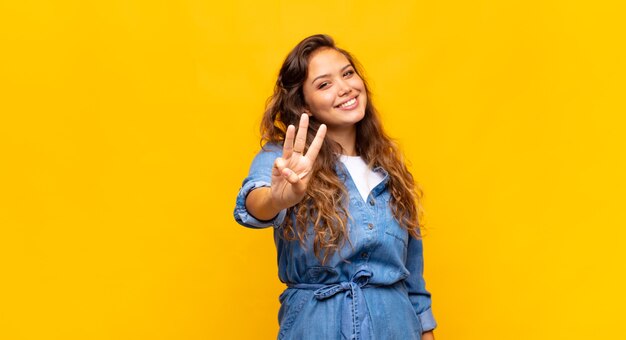 joven y elegante mujer bonita sobre fondo amarillo