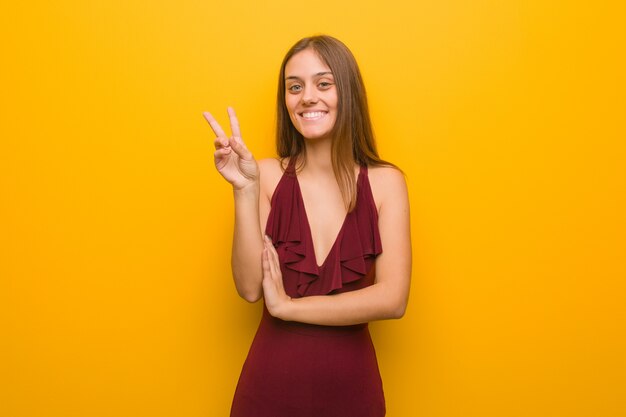 Joven elegante con un vestido que muestra el número dos