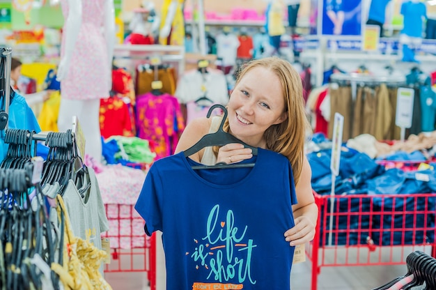 Foto joven elige camisa en tienda