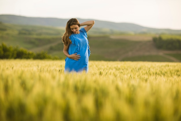 Joven embarazada en el campo