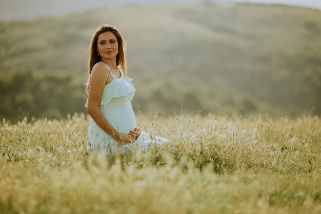 Joven embarazada en el campo