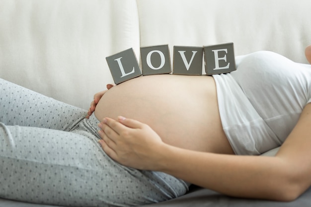 Joven embarazada con la palabra amor en la barriga