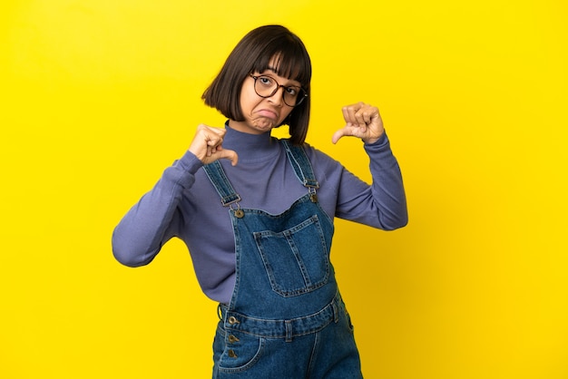 Joven embarazada sobre fondo amarillo aislado orgulloso y satisfecho de sí mismo