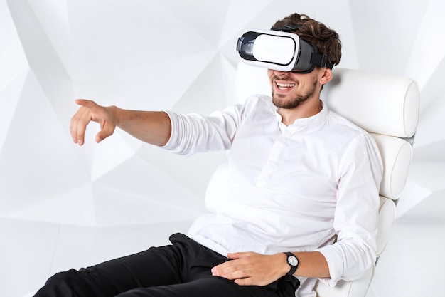 Un joven emocionado está adquiriendo experiencia en el uso de gafas vrheadset de realidad virtual gesticulando con ...