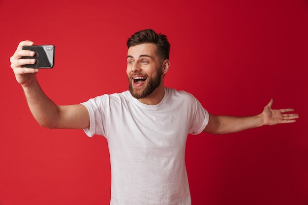 Joven emocional hacer selfie por teléfono móvil.