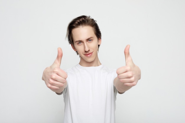 Joven con emociones en su rostro un fondo gris