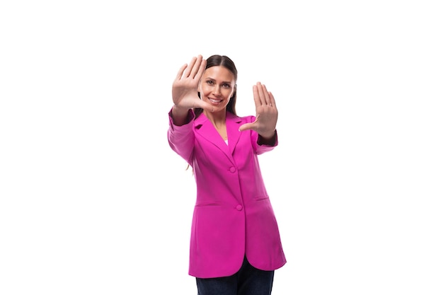 Foto una joven empleada de oficina con cabello negro vestida con una chaqueta rosa parece feliz.