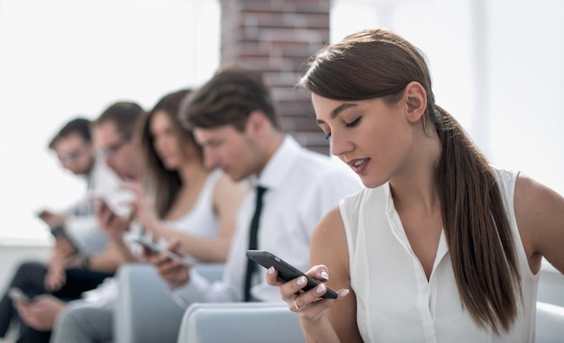 Joven empleado mirando un mensaje de texto en una foto de teléfono inteligente con espacio de copia