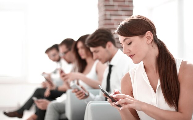 Joven empleado mirando un mensaje de texto en una foto de teléfono inteligente con espacio de copia