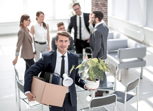 Joven empleado de pie en el cargo en su primer día el concepto de empleo