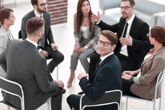 Joven empleado sentado en un seminario sobre trabajo en equipo