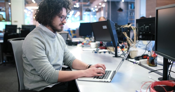 Foto joven emprendedor independiente que trabaja con una computadora portátil en el espacio de coworking