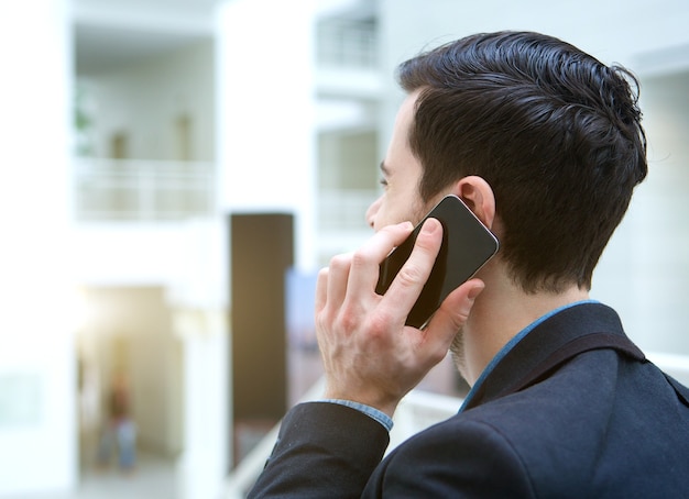 Joven empresa hablando por teléfono móvil