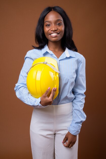 Joven empresaria africana hermosa zulú con casco contra