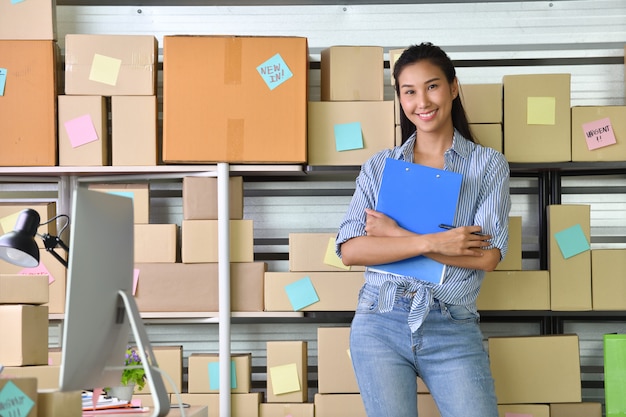 Joven empresaria asiática Propietaria de un negocio que trabaja en su casa para comprar en línea y preparar un paquete