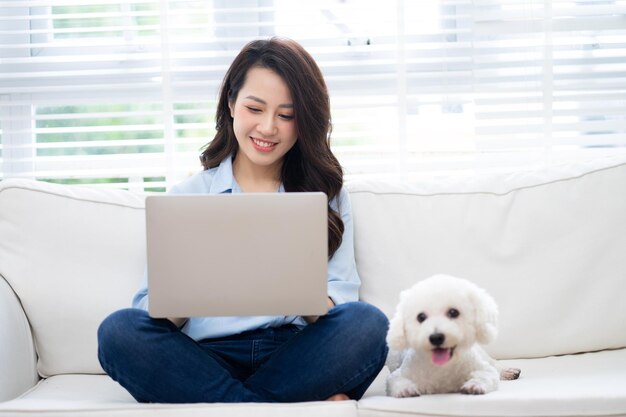 Joven empresaria asiática trabajando en casa con su perro