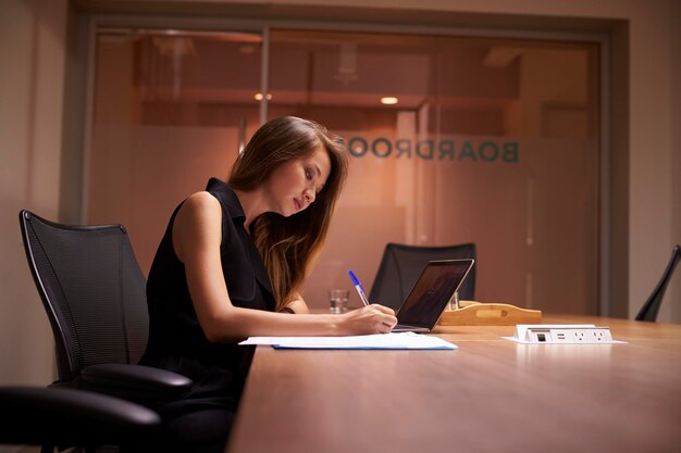 Joven empresaria asiática trabajando sola hasta tarde en una oficina