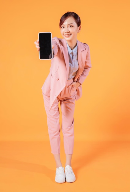 Joven empresaria asiática usando un teléfono inteligente en el fondo