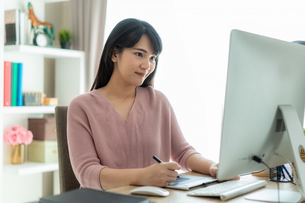 Joven empresaria asiática utilizando computadora trabajo desde casa