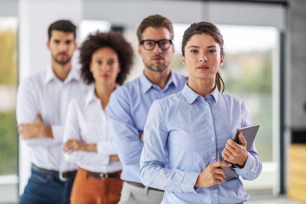 Foto joven empresaria atractiva con tableta en sus manos en firma corporativa.