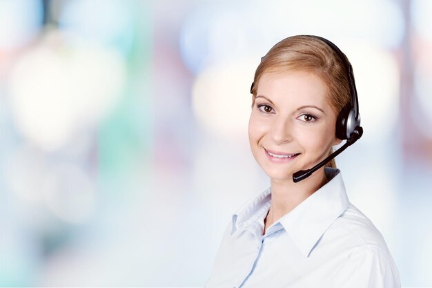 Joven empresaria en auriculares sonriendo a la cámara