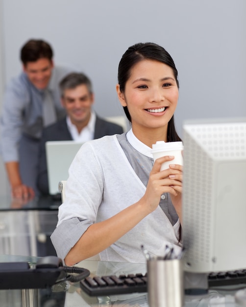 Joven empresaria bebiendo un café en su escritorio