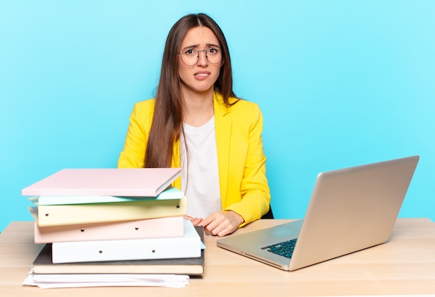 Joven empresaria bonita que se siente despistada, confundida e insegura acerca de qué opción elegir, tratando de resolver el problema