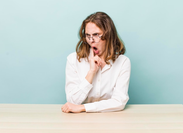 Joven empresaria bonita sentada con una mesa