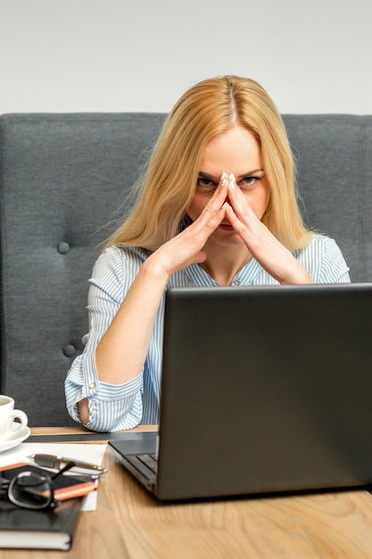 Foto joven empresaria caucásica cansado del trabajo sentado a la mesa en un café