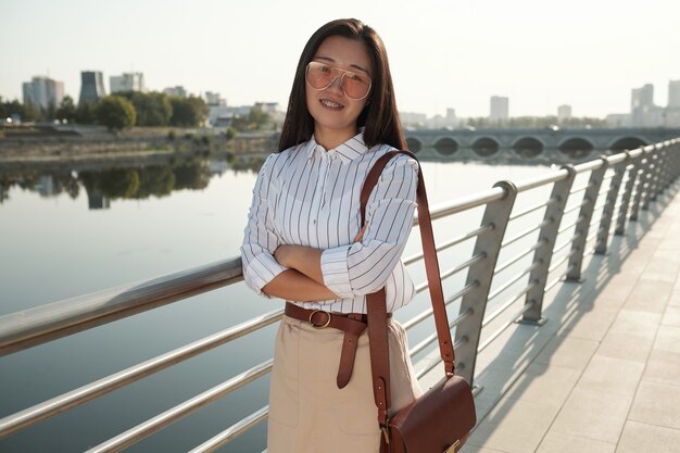 Joven empresaria China de pie junto al río
