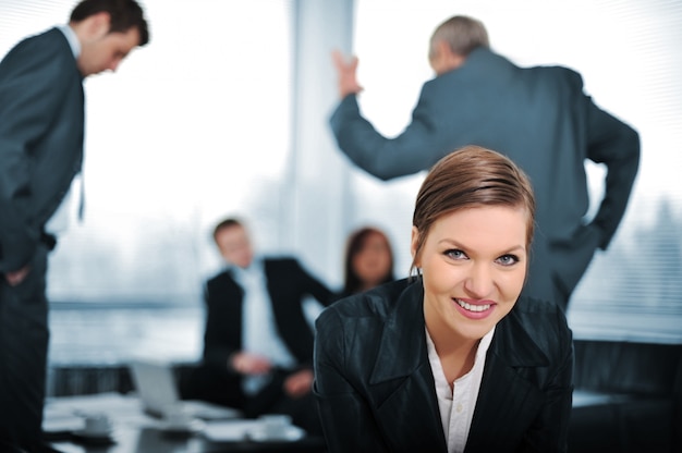 Joven empresaria con colegas en el fondo