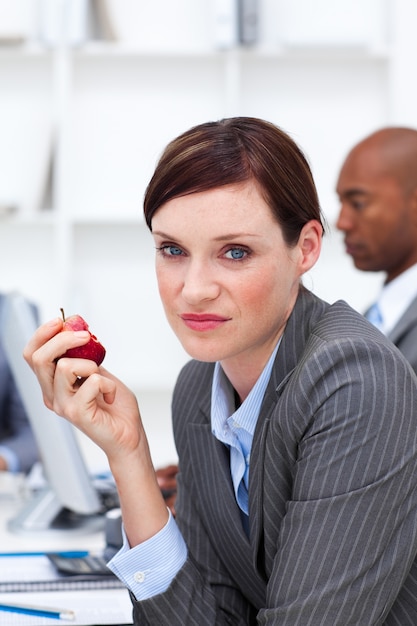 Joven empresaria comiendo una manzana