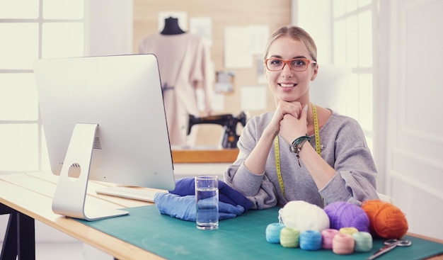 Joven empresaria y diseñadora de moda trabajando en su taller