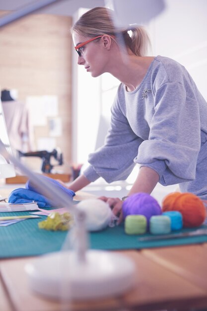 Joven empresaria y diseñadora de moda trabajando en su taller