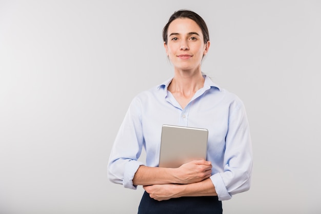 Joven empresaria elegante con touchpad de pie delante de la cámara mientras posa de forma aislada