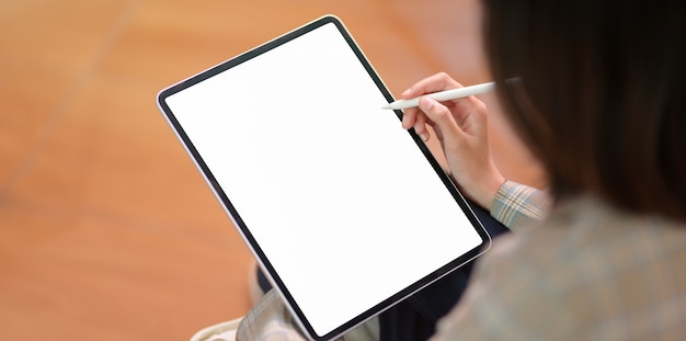 Joven empresaria escribiendo en la tableta de la pantalla en blanco