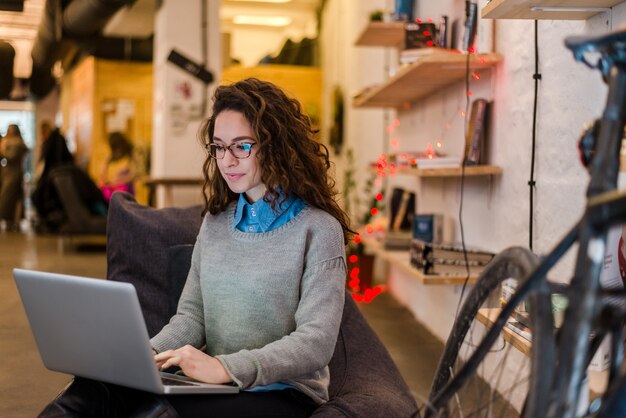 Joven empresaria está preparando una presentación en una computadora portátil.