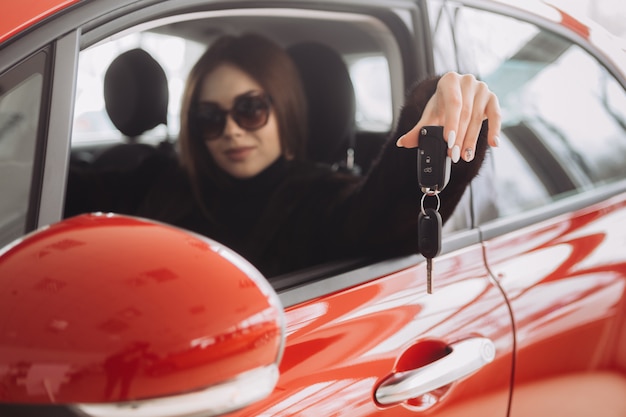 Una joven empresaria está probando autos en una tienda de autos